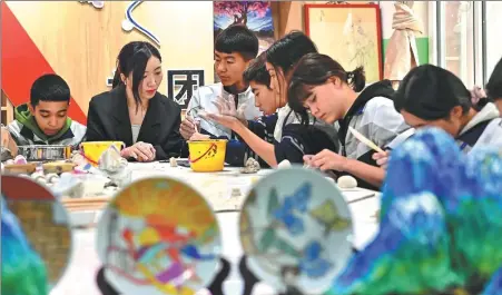  ?? DING LEI / XINHUA ?? A teacher from Jiangxi province instructs students during a pottery class at Xuesong Middle School in Aketao county, Xinjiang Uygur autonomous region, in November.