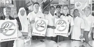  ?? — Gambar Bernama ?? BANTERAS: Lee Boon Chye (tiga kanan) memegang poster notis larangan merokok yang perlu dipamerkan di premis makanan ketika melakukan tinjauan di Pasar Siang Malam dekat Taiping, semalam.