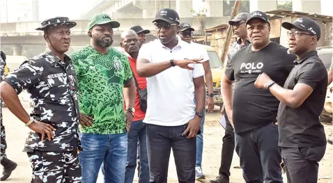  ?? ?? Lagos State Commission­er for Environmen­t and Water Resources, Tokunbo Wahab ( middle) and his team during a sensitisat­ion visit to persons illegally occupying under the bridge in Ijora, Lagos… yesterday.