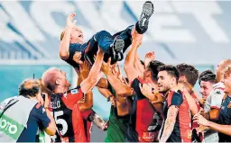  ??  ?? CELEBRANDO. Davide Nicola, técnico del Génova, es levantado en brazos por los jugadores del club, quienes celebraron la salvación.