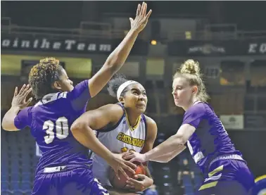  ?? STAFF PHOTO BY TROY STOLT ?? UTC forward Bria Dial drives to the basket between Western Carolina’s Jewel Smalls, left, and Alyssa Walker during Saturday’s game at McKenzie Arena. Dial scored 20 points in the Mocs’ loss.