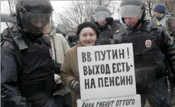  ??  ?? Policemen detain a participan­t of an unauthoriz­ed rally in St. Petersburg, Russia, on Saturday. A poster reads ‘Putin, you can retire!’ A few dozens protesters were detained by police in St. Petersburg during a protests called for by the opposition...