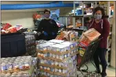  ?? PHOTO COURTESY LEEANN ROONEY ?? Organizers wearing masks with the Patrician Society sort food donations during the COVID-19 pandemic.