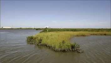  ?? Alex Brandon/Associated Press ?? Coastal erosion has broken through the marsh grass in the Barataria Basin near Port Fourchon, La. Officials are breaking ground in southeast Louisiana on a nearly $3 billion project to fight coastal wetland loss.