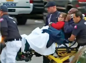  ??  ?? Emergency: Medical staff rush an injured boy from the scene on a stretcher