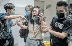  ?? Picture: DALE DE LA REY/AFP ?? CLAMPING DOWN: A woman reacts after she was hit with pepper spray used by police as they cleared a street of protesters rallying against a new national security law in Hong Kong yesterday, on the 23rd anniversar­y of the city’s handover from Britain to China