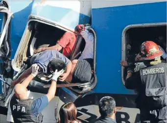  ?? Photos: REUTERS ?? Pulled free: Rescuers help trapped passengers from a commuter train that crashed into the buffers at Once train station in Buenos Aires yesterday.