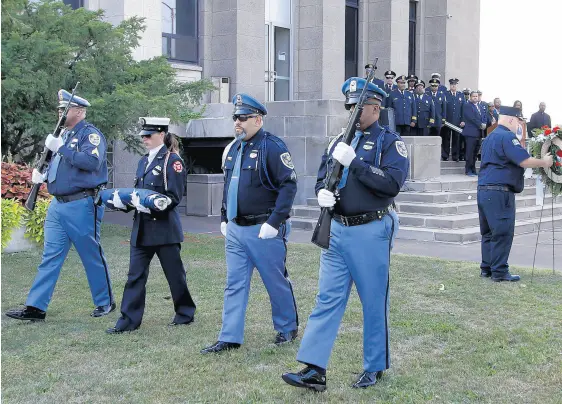  ??  ?? A color guard marches to raise the flag to half-staff during a 9/11 memorial service at the Gary City Hall on Saturday. JOHN SMIERCIAK/POST-TRIBUNE PHOTOS