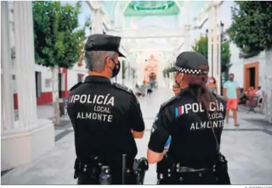  ?? H. INFORMACIÓ­N ?? Dos agentes de la Policía Local de Almonte bajo la catedral efímera.