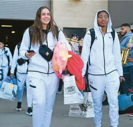  ?? KEVIN RICHARDSON/STAFF ?? Maryland women’s basketball teammates Faith Masonius, left, and Shyanne Sellers head to their bus on Wednesday in College Park en route to Stanford, California, for the NCAA Tournament.