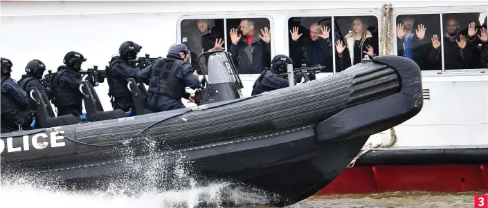  ??  ?? Boarding party: The speedboat of armed officers pulls alongside the tourist boat, while volunteers posing as hostages press their hands against the windows 3