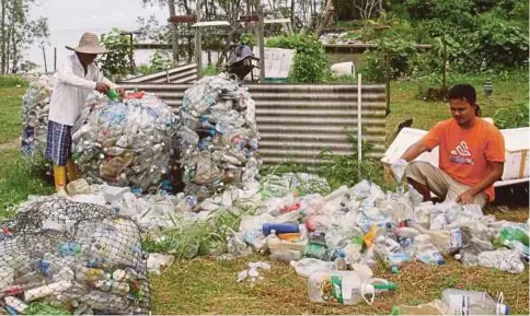  ??  ?? MD Said (kiri) dan anaknya mengumpul plastik yang dikutip untuk dijual.