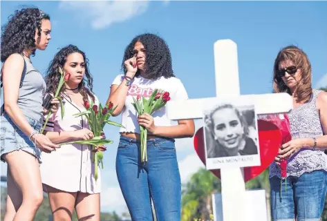  ??  ?? Estudiante­s de la preparator­ia Marjory Stoneman Douglas lloraron frente a las cruces que fueron colocadas en memoria de las víctimas del tiroteo.