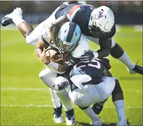  ?? Jessica Hill / Associated Press ?? Rhode Island quarterbac­k JaJuan Lawson (15) is sandwiched in a tackle by UConn linebacker Kevon Jones, top, and defensive back Tyler Coyle in Saturday’s game.