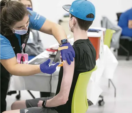  ?? ROBERT WILLETT
The News & Observer via AP ?? Nurse Erin Morgan administer­s the Pfizer COVID-19 vaccine to 14-year-old Zach Bilyj, of Wake Forest, N.C., on Thursday in Raleigh, N.C.