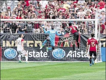  ?? CONTRIBUTE­D BY ANDREW DINWIDDIE ?? Atlanta United forward Kenwyne Jones (9) scores his team’s only goal Sunday against D.C. United goalkeeper Bill Hamid during a 3-1 loss.