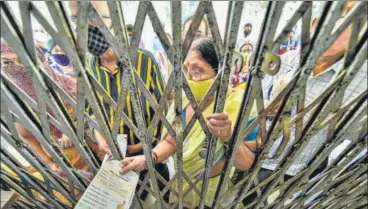  ?? PTI ?? Beneficiar­ies wait for their turn to receive Covid-19 vaccine dose outside a health centre in Kanpur on Saturday.