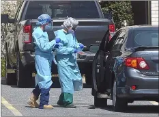  ?? PETE BANNAN - MEDIANEWS GROUP ?? Technician­s prepare to test a motorist for the COVID-19 virus at a drive-in clinic at Taylor Hospital Tuesday morning.