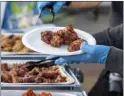  ?? ?? Hot meals provided by McGinest, a Wing Stop restaurant franchise owner, are served at the Whitsett Tiny Home Village in North Hollywood on Wednesday.