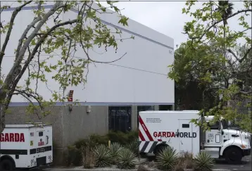  ?? RICHARD VOGEL — THE ASSOCIATED PRESS ?? Armored trucks are parked outside the Gardaworld facility in the Sylmar section of Los Angeles on Thursday. Thieves stole as much $30million in an Easter Sunday burglary at a Los Angeles money storage facility in one of the largest cash heists in city history. Such a massive amount of cash would be difficult to move and transport.