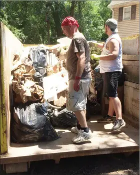  ?? EVAN BRANDT — MEDIANEWS GROUP ?? Erin and Julian Weber fill a dumpster with belongings from their Walnut Street home destroyed in Thursday’s flash flood.