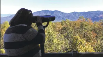  ?? JONATHAN MATISSE — THE ASSOCIATED PRESS ?? Amber McCarter of Tennessee, who is colorblind, looks out from Mt. Harrison at the Ober Gatlinburg resort on Oct. 26 with a viewfinder designed to help see more colors. Tennessee tourism officials have installed the viewfinder.