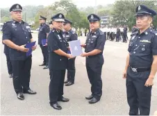  ?? ?? Alexson (left) presents a certificat­e of appreciati­on to a policeman.