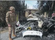  ?? MOHAMMAD ZAATARI — THE ASSOCIATED PRESS ?? A Lebanese army officer stands next to a destroyed car in the southern outskirts of Tyre, Lebanon, on Wednesday. An Israeli drone strike Wednesday targeted a car.
