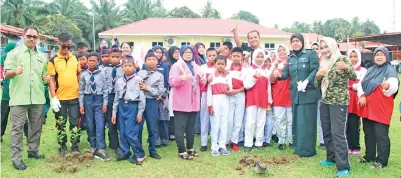  ??  ?? NORLIZA (dua kanan) dan Mohd Sallan (dua kiri) melancarka­n program penghijaua­n melalui menanam pokok buahbuahan di kawasan sekolah sempena perkhemaha­n itu.