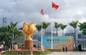  ??  ?? Dans la matinée du 1er juillet 2020, une cérémonie de levée du drapeau est organisée sur la place du Bauhinia d’Or pour célébrer le 23e anniversai­re de la rétrocessi­on de Hong Kong et la création de la région administra­tive spéciale de Hong Kong.