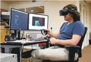  ?? GARY REYES/STAFF ?? Kyle Emmerich works with an Oculus 3-D headset in the virtual reality research department at Roblox in San Mateo.