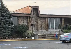  ?? PLAIN DEALER THE (CLEVELAND) ?? A parishione­r arrives for morning Mass July 25 at St. Columbkill­e in Parma, a south suburb of Cleveland. Health authoritie­s are investigat­ing 11 cases of Legionnair­es’ disease, including one death, among people who attend church there.