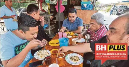  ??  ?? Pelanggan menikmati roti canai berharga 50 sen di warung Rasmah.