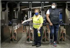  ?? SETH WENIG — THE ASSOCIATED PRESS ?? An MTA employee cleans turnstiles as commuters pass through in New York, Monday, June 8, 2020. After three months of a coronaviru­s crisis followed by protests and unrest, New York City is trying to turn a page when a limited range of industries reopen Monday.