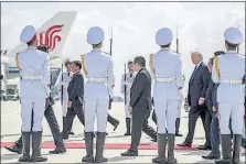  ?? [ANDREW HARNIK/THE ASSOCIATED PRESS] ?? Members of a Vietnamese honor guard stand as President Donald Trump, right, arrives Friday at Danang Internatio­nal Airport in Vietnam.