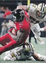  ?? David Goldman Associated Press ?? THE FALCONS’ Julio Jones is brought down by Saints’ Manti Te’o (51) and Marshon Lattimore.