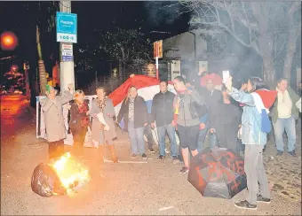  ??  ?? Un grupo de manifestan­tes prende fuego a una bolsa de hule durante el escrache realizado anoche frente a la casa del diputado José María Ibáñez, quien está ausente.