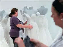  ?? XINHUA ?? Employees settle bridal and prom dresses for display at US brand Mon Cheri’s company showroom in Trenton of New Jersey, the United States.