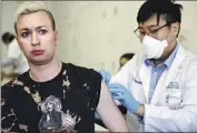  ?? Mario Tama Getty Images ?? STUDENT pharmacist Charles Liu prepares to give a monkeypox shot at a West Hollywood Library clinic.