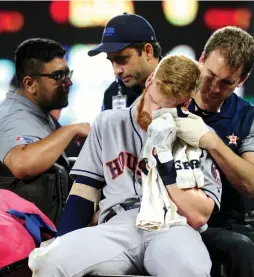  ??  ?? HOUSTON ASTROS third baseman Colin Moran gets carted off the field after fouling a ball off his face in the Astros’ 8-4 road victory over the Baltimore Orioles on Saturday. Moran, who was hospitaliz­ed, was playing in only his second career major league...