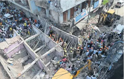  ?? AFP ?? Members of the National Disaster Response Force search for victims after a building collapsed in New Delhi on Wednesday. —