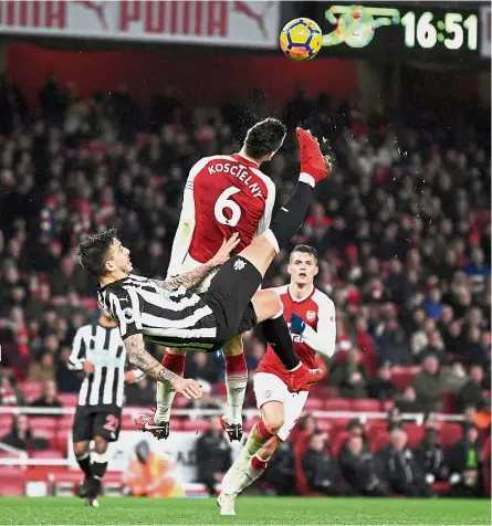  ?? — Reuters ?? Air raid: Newcastle’s Joselu (second from left) vying with Arsenal’s Laurent Koscielny at the Emirates on Saturday.