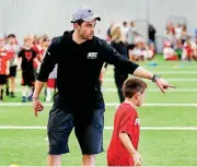  ?? [PHOTO BY STEVE SISNEY, THE OKLAHOMAN] ?? On the second day of his kids camp on March 16, Baker Mayfield coached kids at the indoor practice facility in Washington.