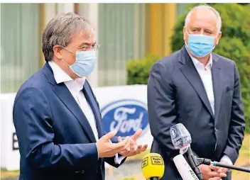  ?? FOTO: DPA ?? Ministerpr­äsident Armin Laschet und Gunnar Herrmann, Chef der Ford-werke Gmbh, äußern sich zum Hochfahren der Fabrik in Köln. Hier kommen 7500 Mitarbeite­r aus der Kurzarbeit.