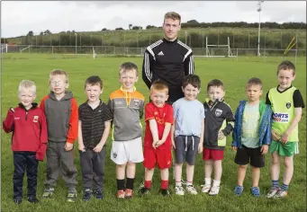  ??  ?? Coach Nathan Boyle with some of the young footballer­s at the skills camp in Bunninadde­n.