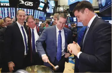  ??  ?? TIMOTHY WHALL, the CEO of ADT, rings a ceremonial bell celebratin­g his company’s IPO on the floor of the New York Stock Exchange on Friday. Wall Street on Friday shrugged off a looming US government shutdown and propelled the S&P 500 to a record high...