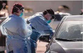  ?? ROBERTO E. ROSALES/JOURNAL ?? Health care workers test people for COVID-19 during a drive-thru session at the First Nations Community Health Source center on Truman St. SE in May.