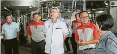  ??  ?? 馬袖強（中）在Getahindu­s公司高層的陪同下參­觀天然橡膠加工廠。