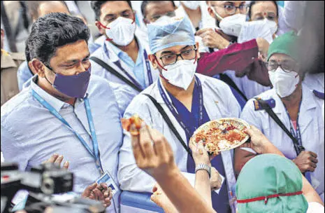  ?? BLOOMBERG ?? Employees welcome health workers carrying Covid vaccines at a hospital in Mumbai on Saturday.