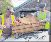 ?? ?? Liam Aherne, Saida and Pat Fleming lining a wall basket in preparatio­n for summer planting.